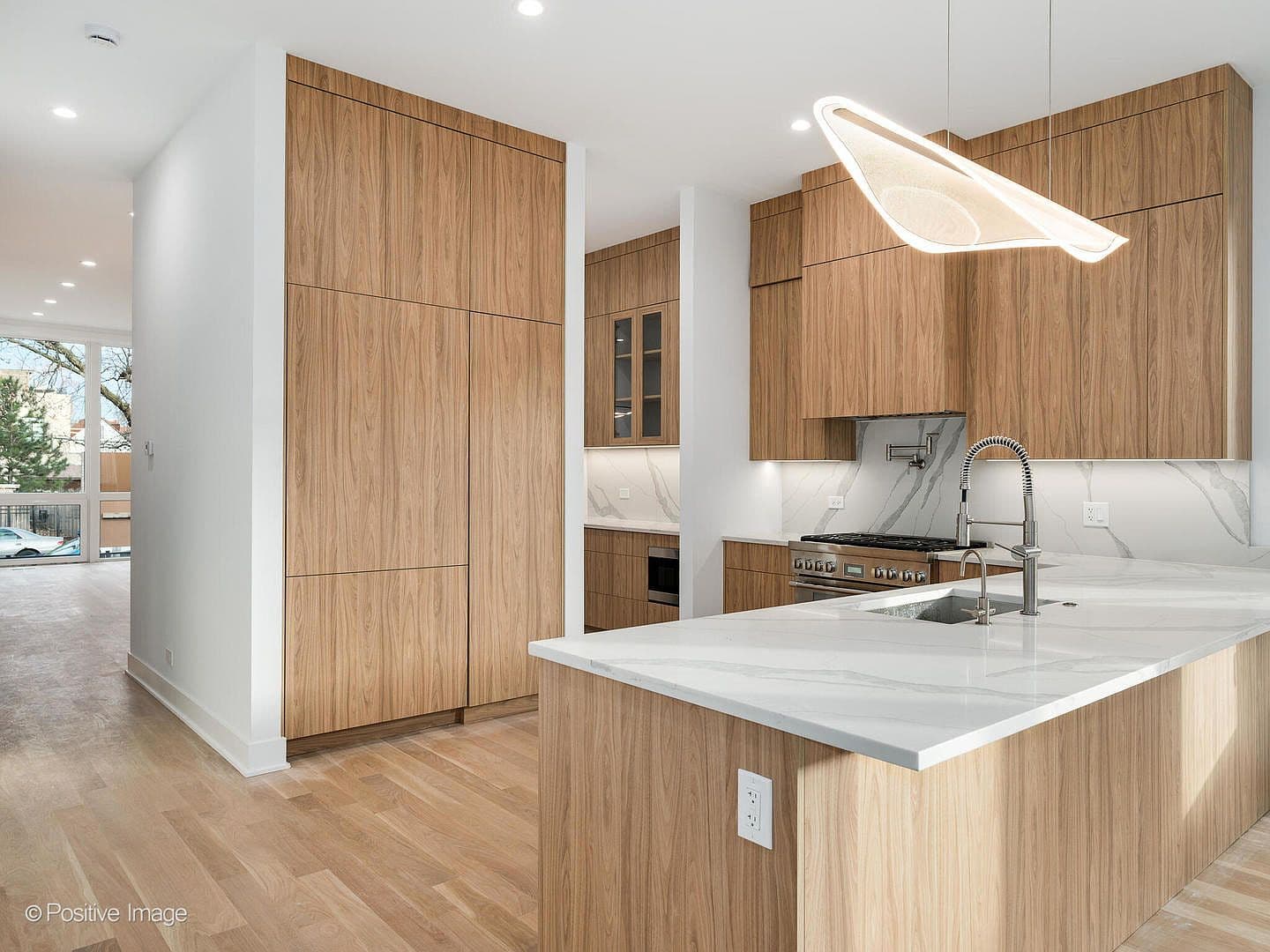 Custom walnut cabinetry and quartz waterfall island
