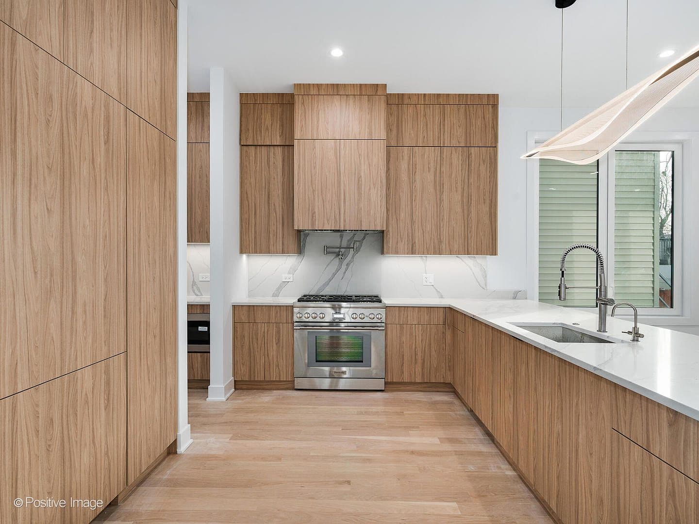 Chef's kitchen with pro-grade range and marble backsplash