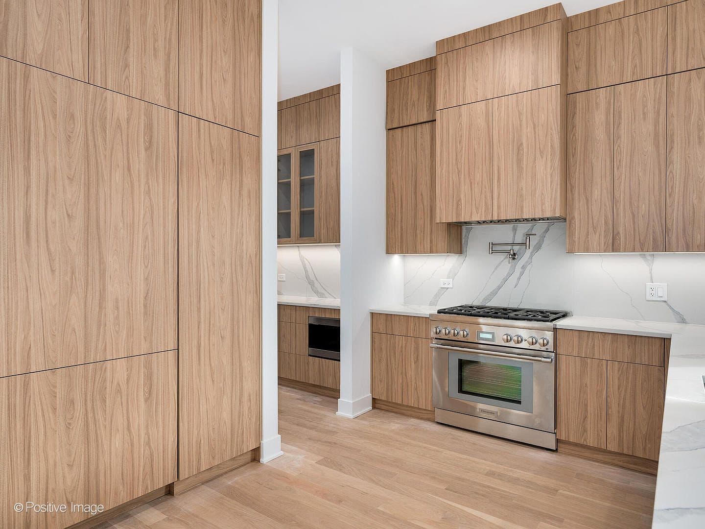 Floor-to-ceiling walnut pantry cabinetry and stainless range