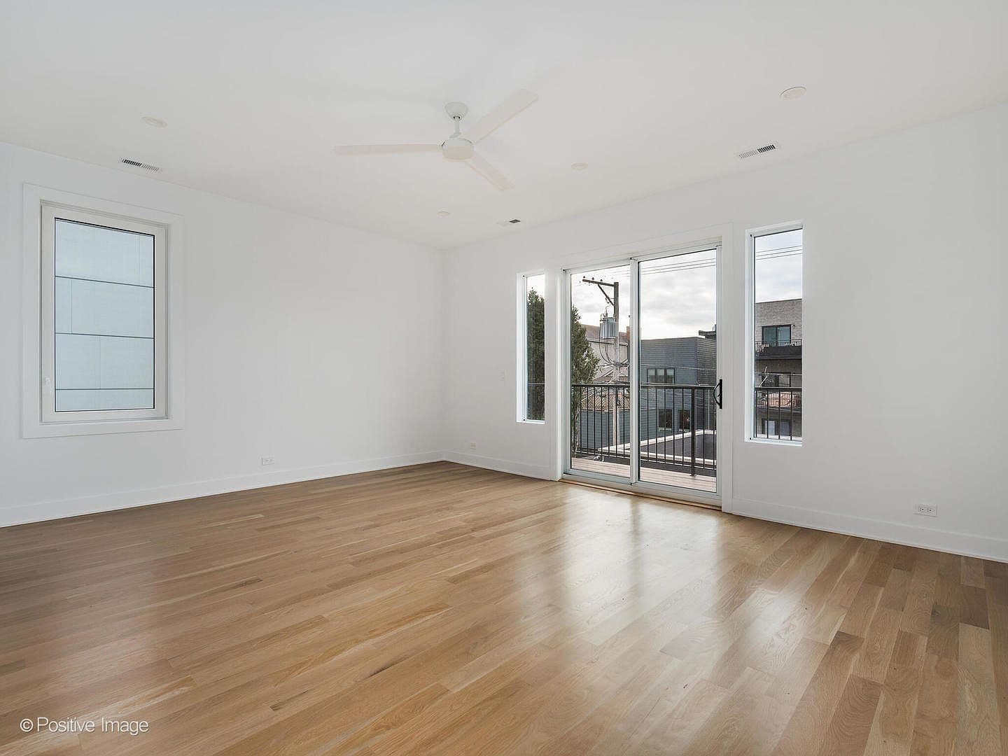 Primary suite with private balcony and ceiling fan