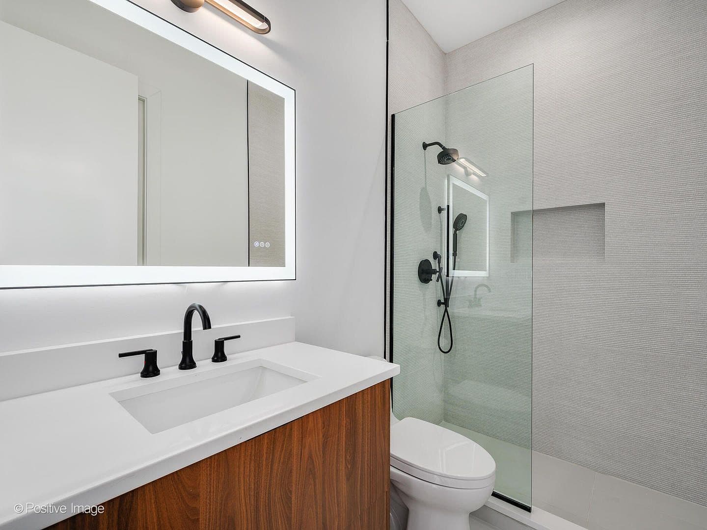 Sleek bathroom with walk-in shower and matte-black fixtures