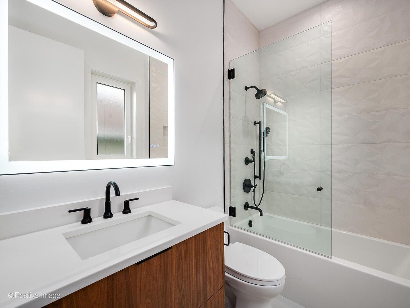 Modern bath with glass-shielded tub and textured tile
