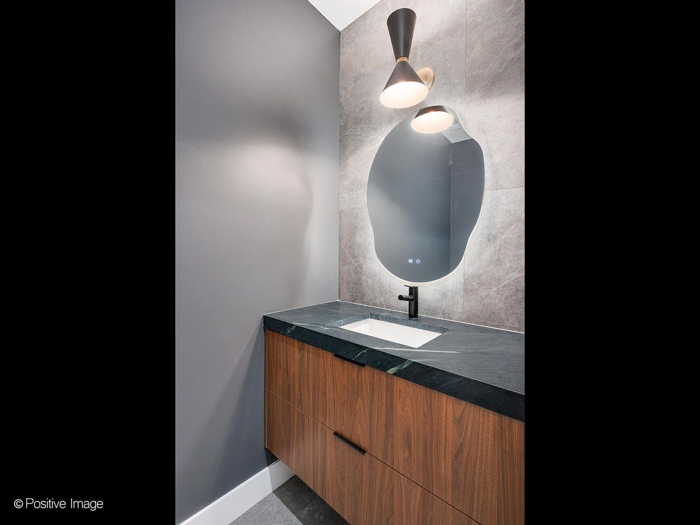 Chic powder room with soapstone counter and stone wall