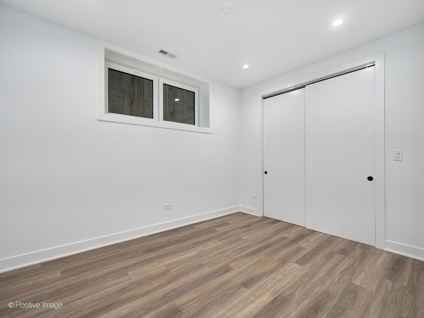 Lower-level bedroom with sliding closet doors
