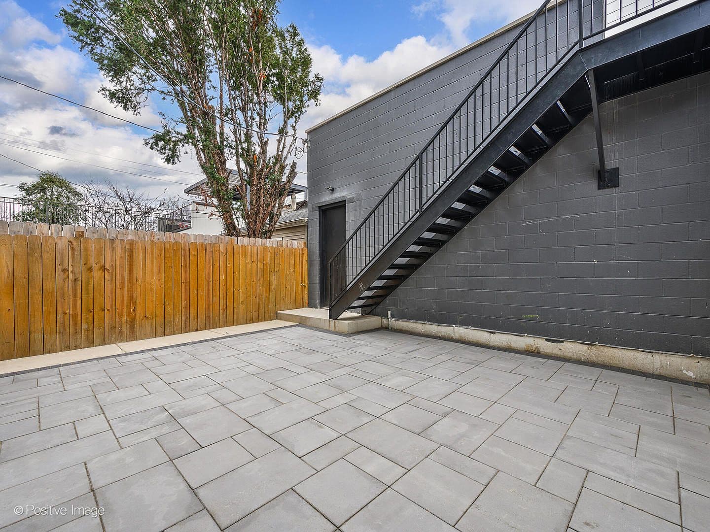 Paver patio with steel staircase to garage roof deck