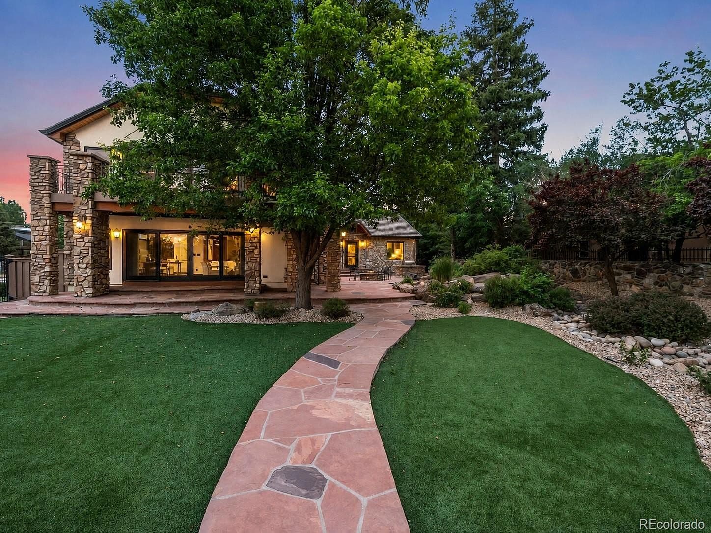 A flagstone path winds through the lush, landscaped yard.