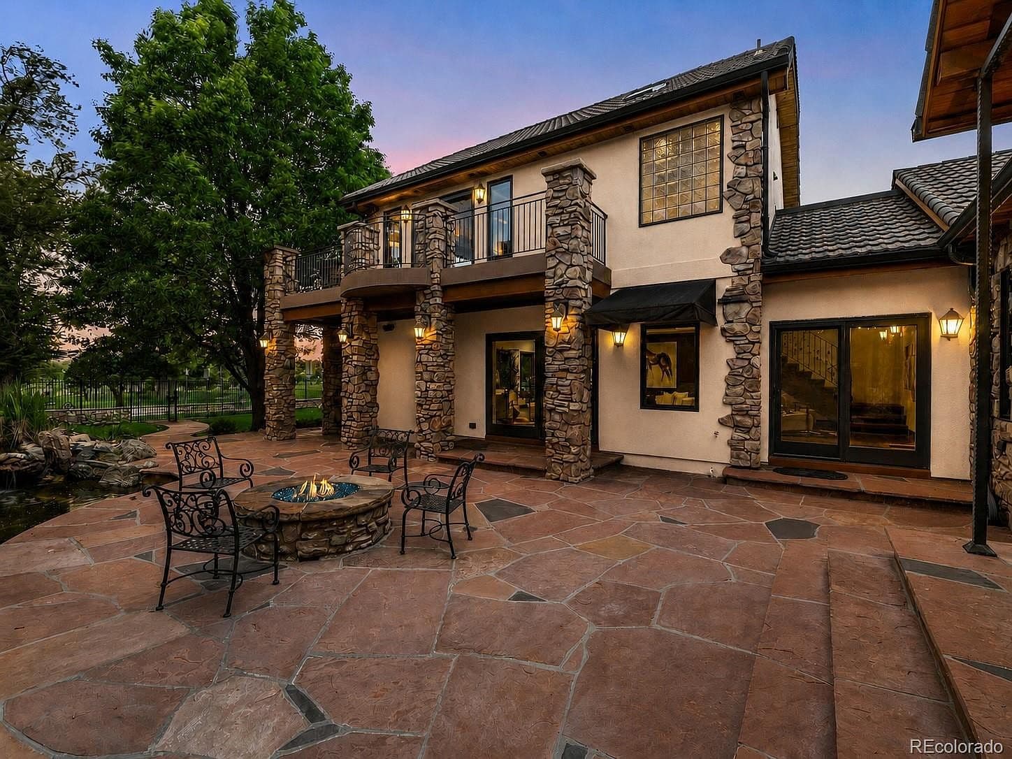 Stone columns frame the balcony above the outdoor entertaining space.