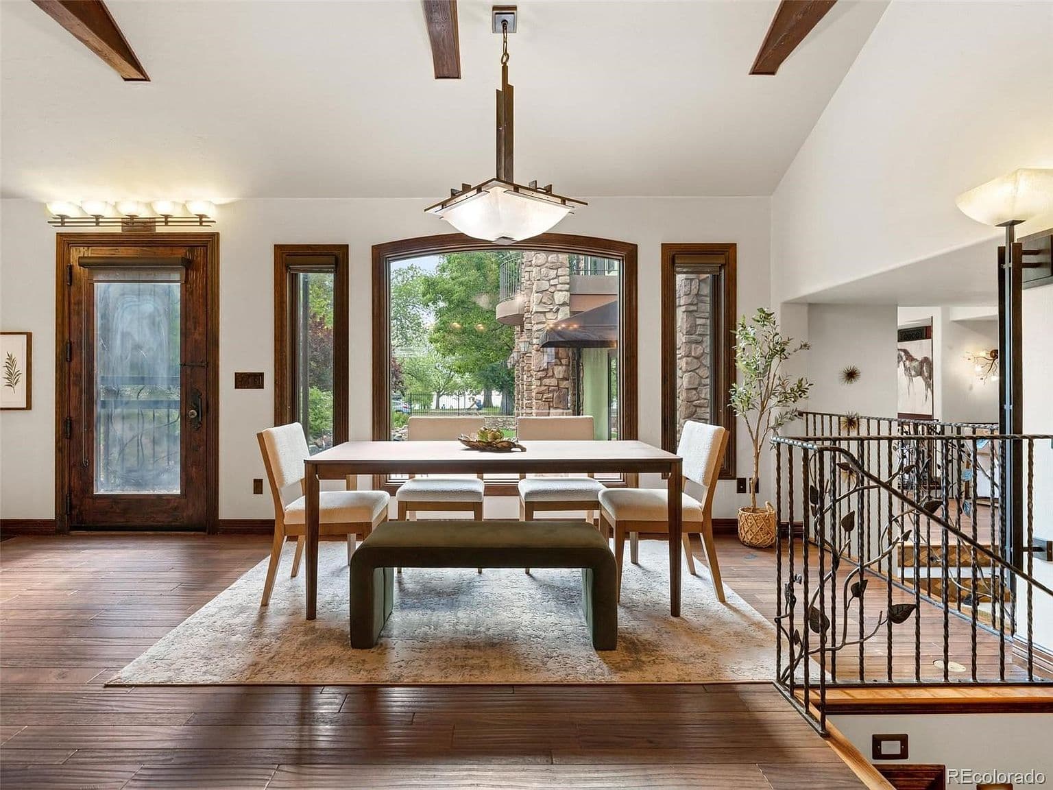 Sunlit dining space with warm wood floors and garden views