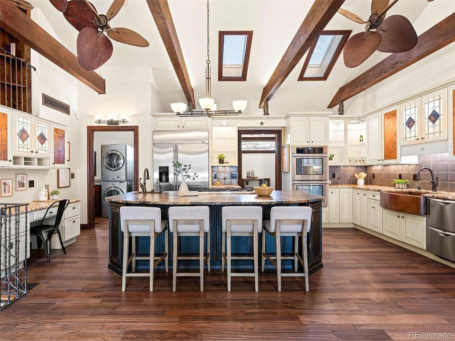 Vaulted kitchen features a generous island and skylights