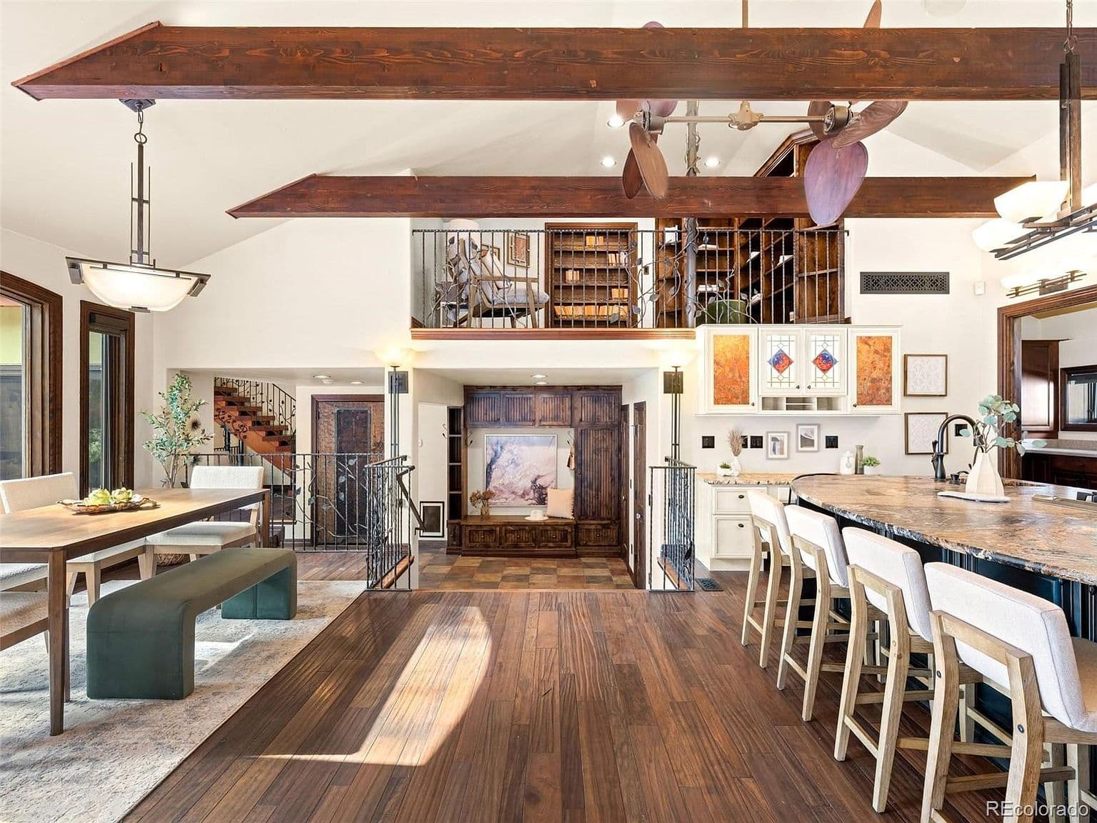 Open dining and kitchen areas framed by exposed beams