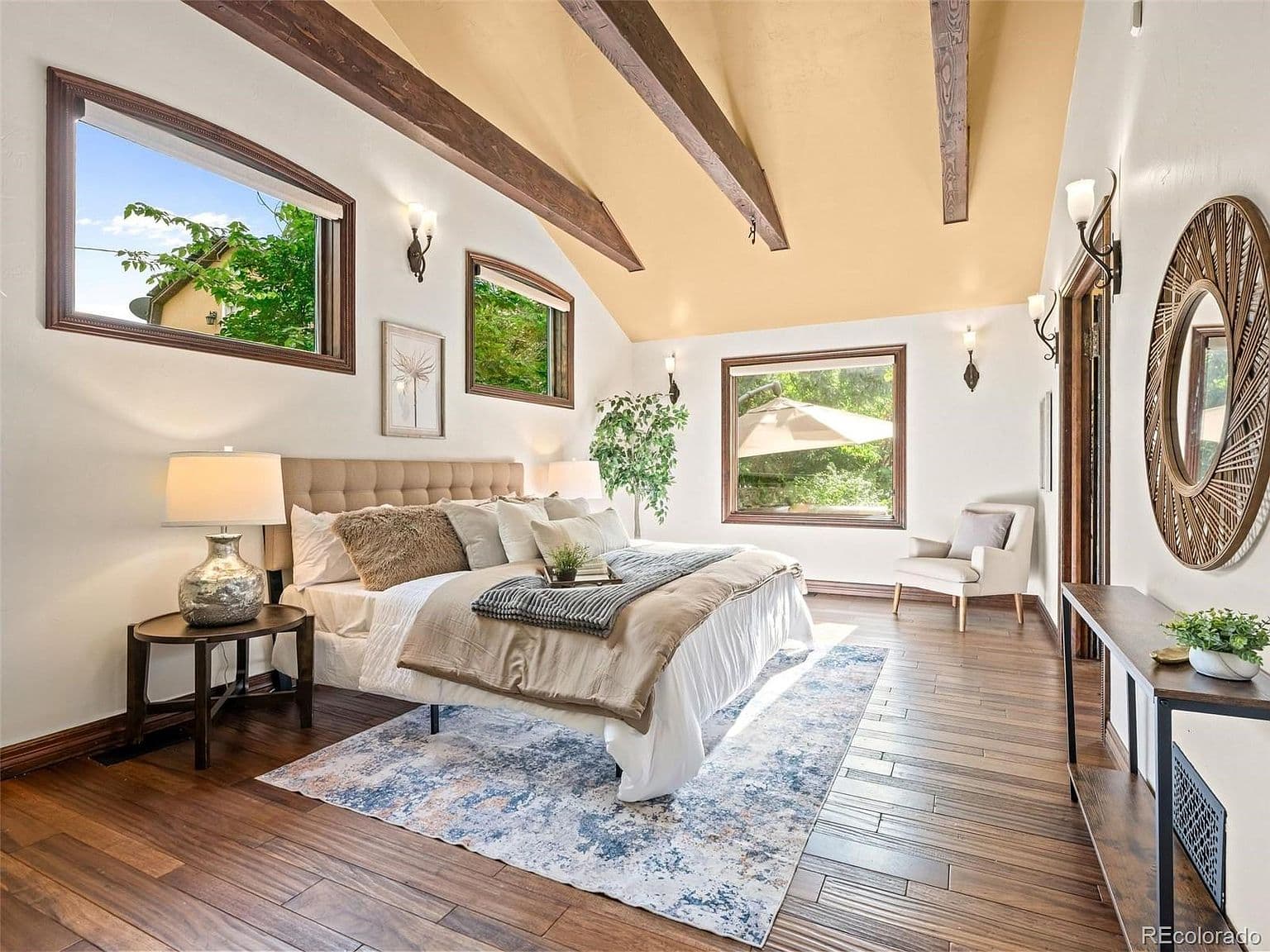 Vaulted ceilings and exposed beams elevate the spacious primary bedroom