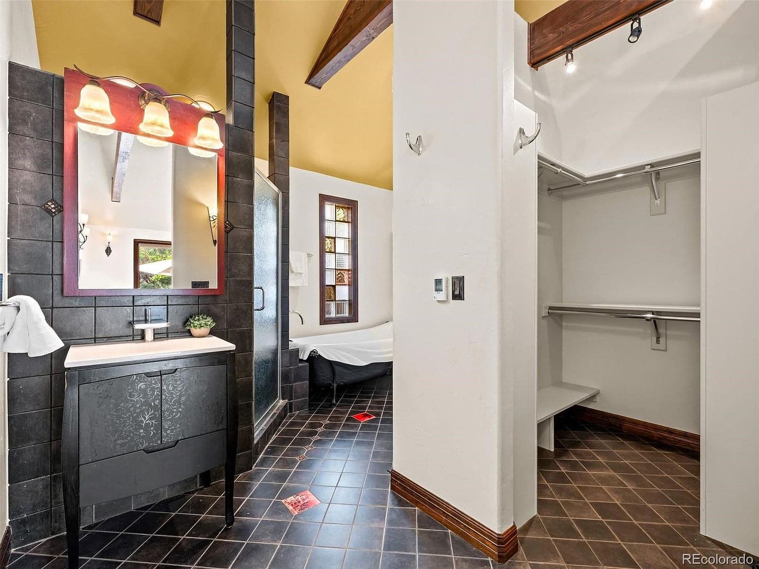 Primary bath pairs a soaking tub with walk-in closet