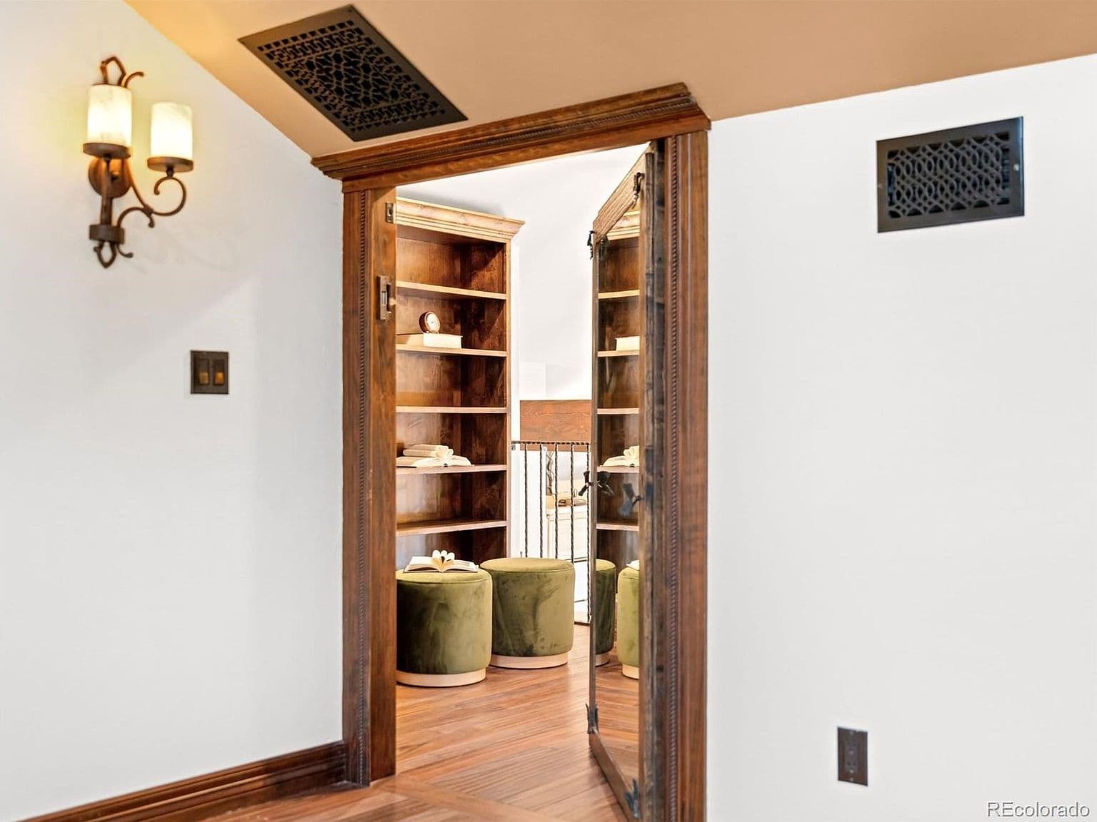 A mirrored doorway reveals a cozy upstairs reading nook.