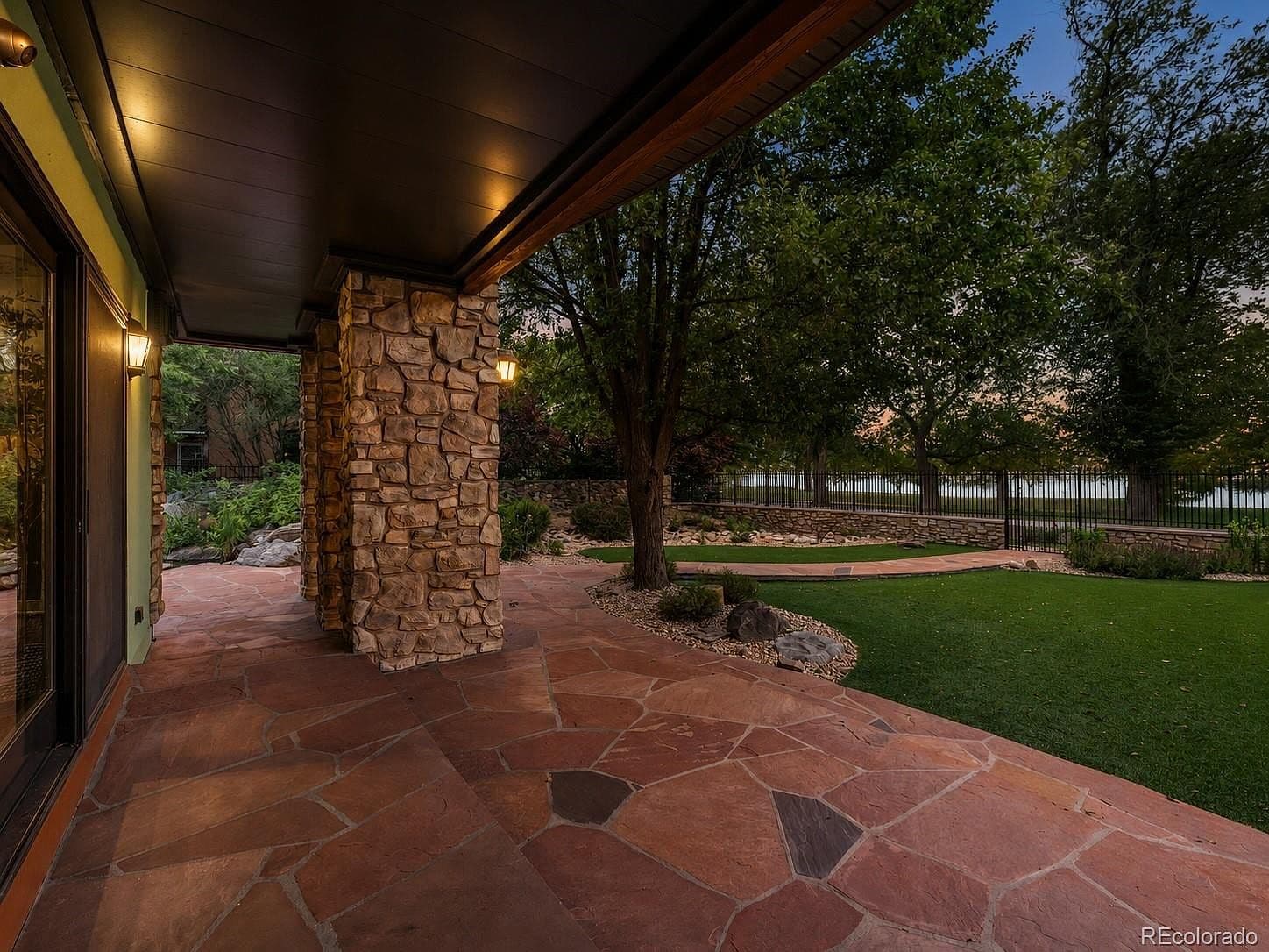 Covered flagstone patio opens to a landscaped yard