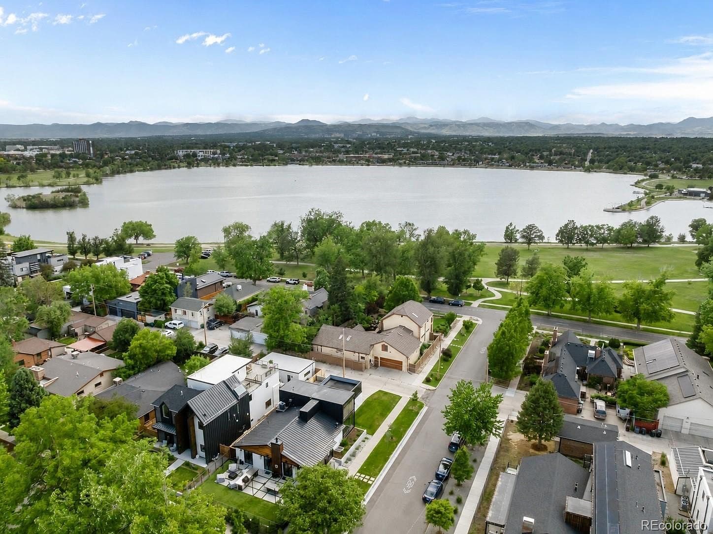 Aerial view showcases the neighborhood, lake and mountains