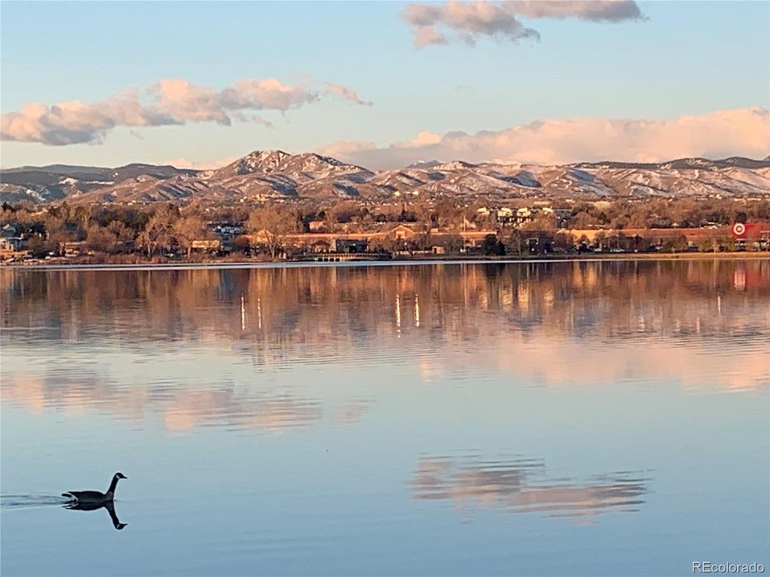 Still lake waters reflect the mountains at dusk