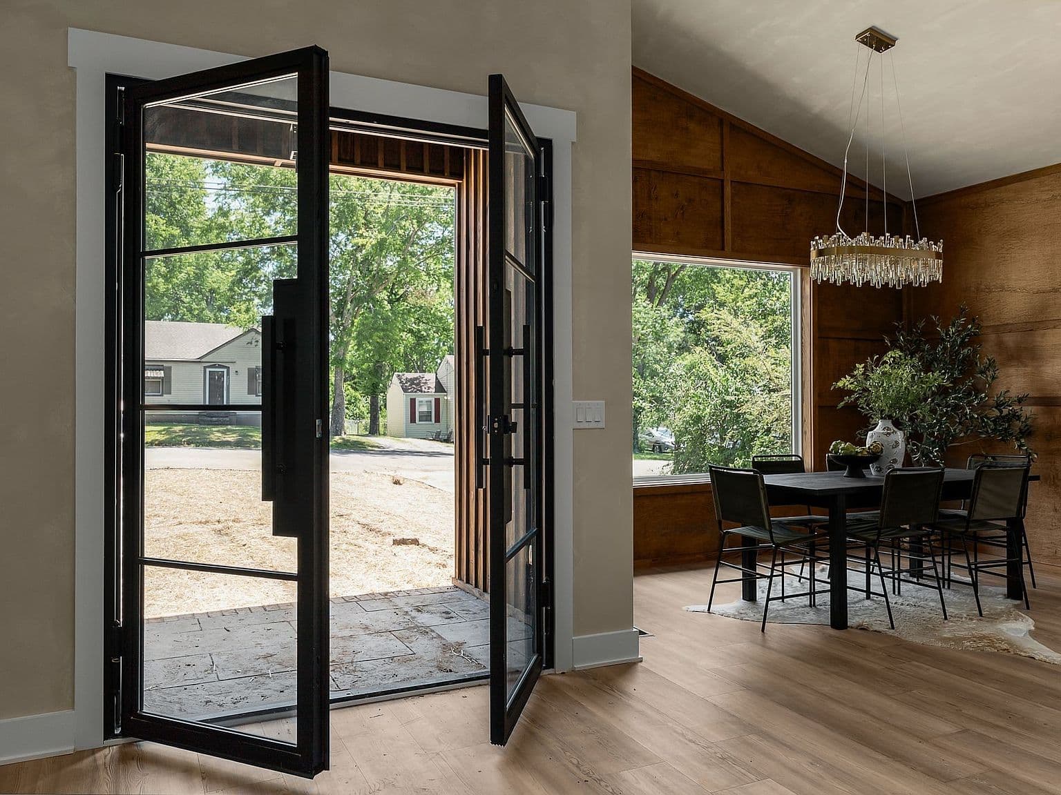Indoor-outdoor living through grand iron-framed doors.