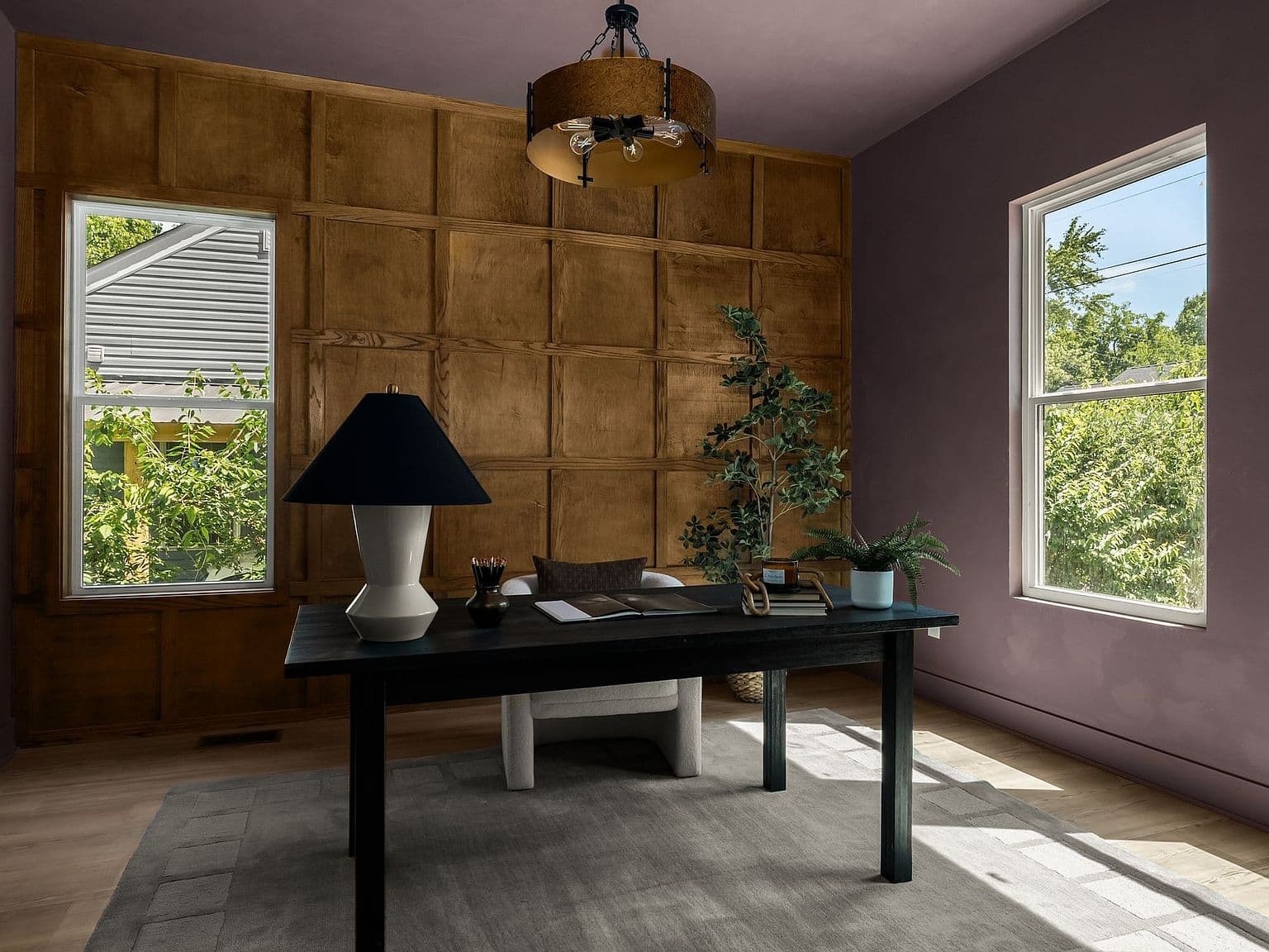 Sunlit home office with paneled accent wall.