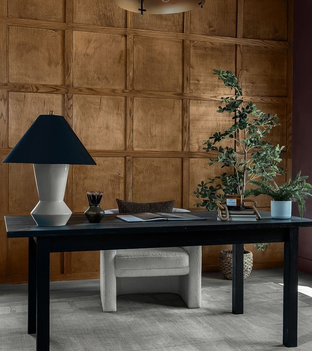 Designer office vignette with rich wood paneling.