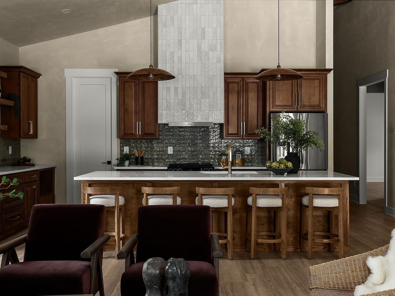 Soaring ceilings frame the kitchen’s custom cabinetry.