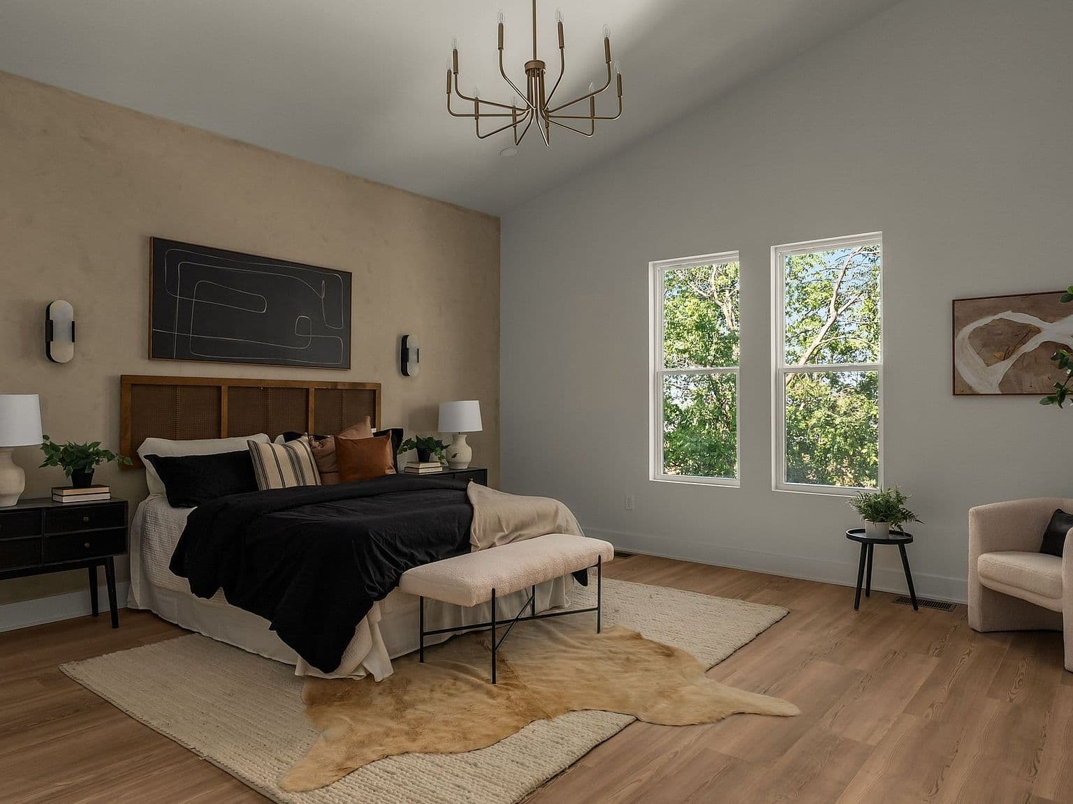Vaulted primary bedroom with treetop views and designer lighting.