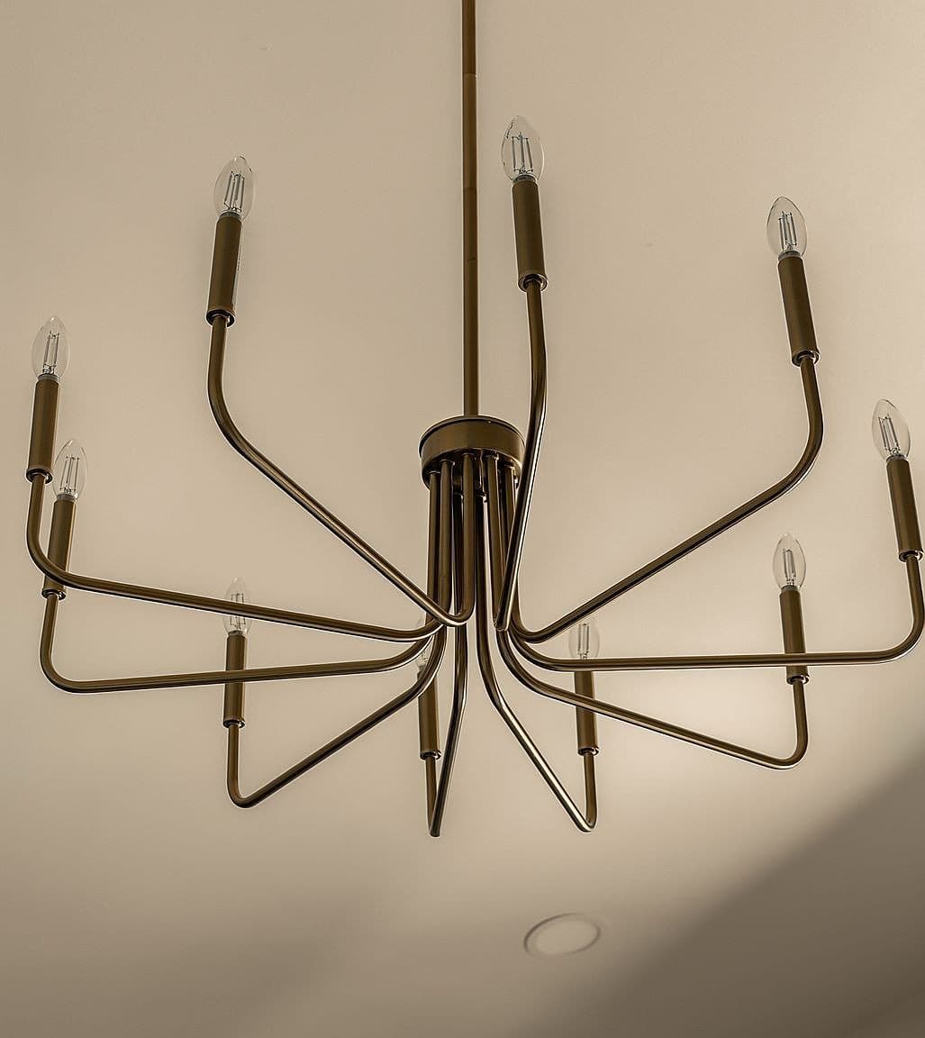 Statement chandelier adds modern elegance to vaulted ceiling.