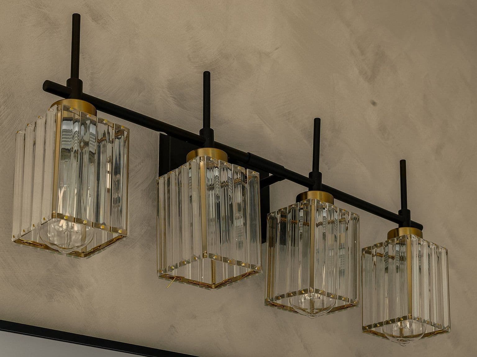 Designer light bar shines over oversized vanity mirrors.