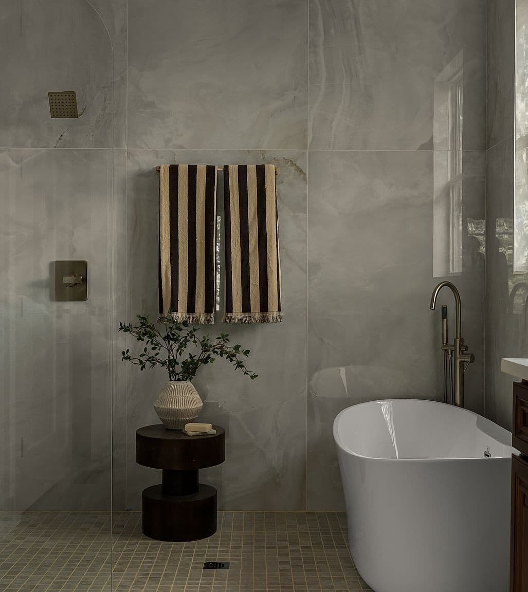 Curbless wet-room with soaking tub and sleek tilework.