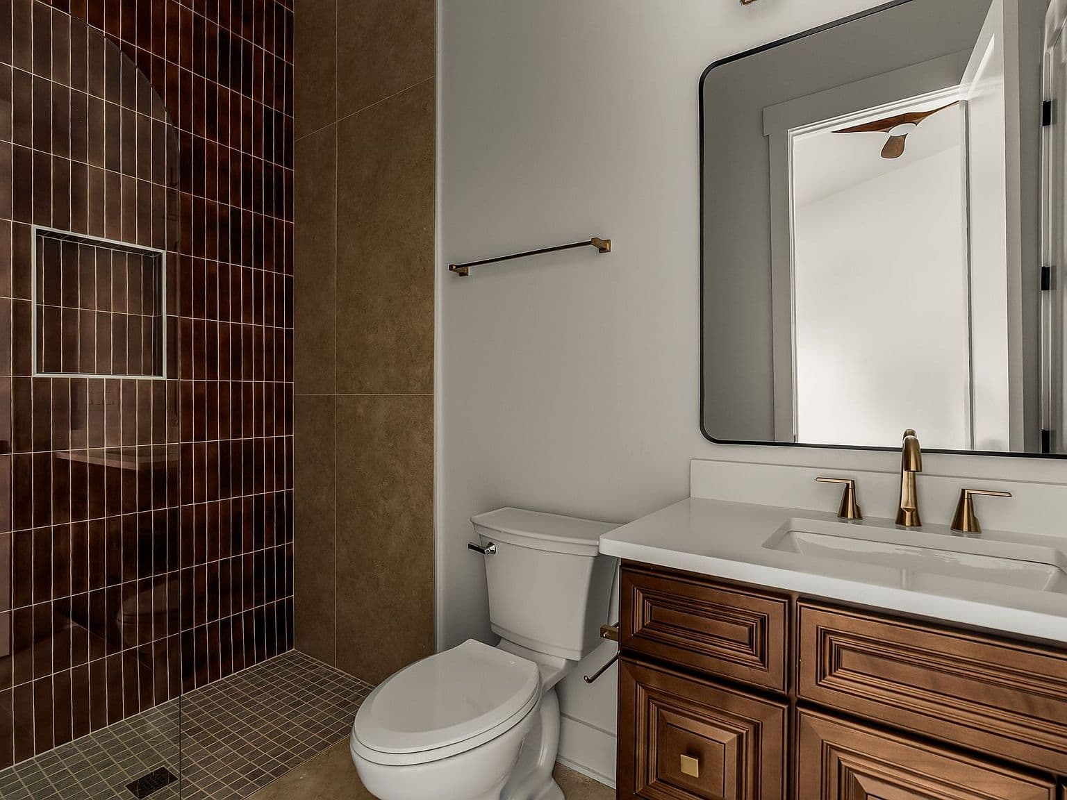 Designer bath with bold tile shower and brass fixtures.