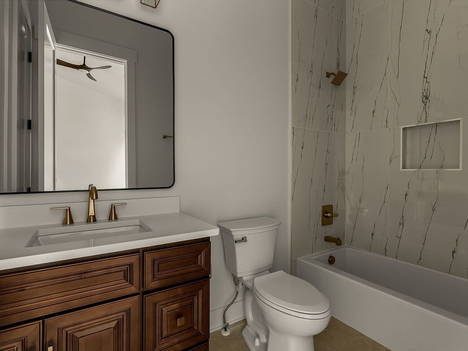Sleek bath with marble-look tile and modern vanity.