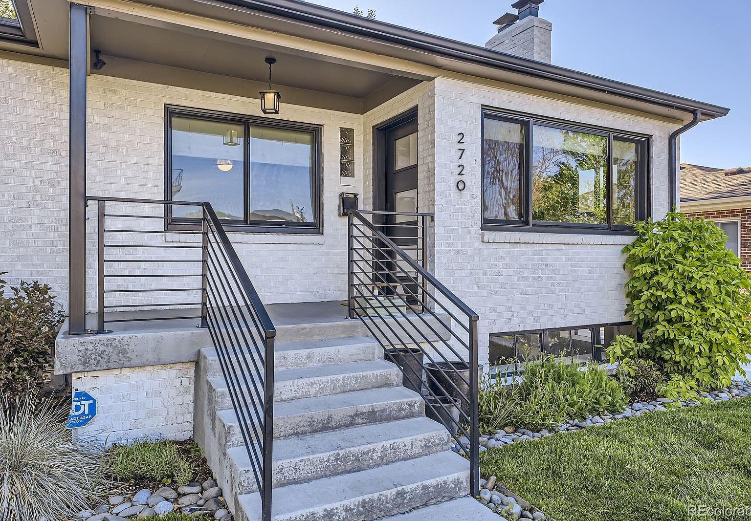 Covered front porch pairs white brick with modern railings
