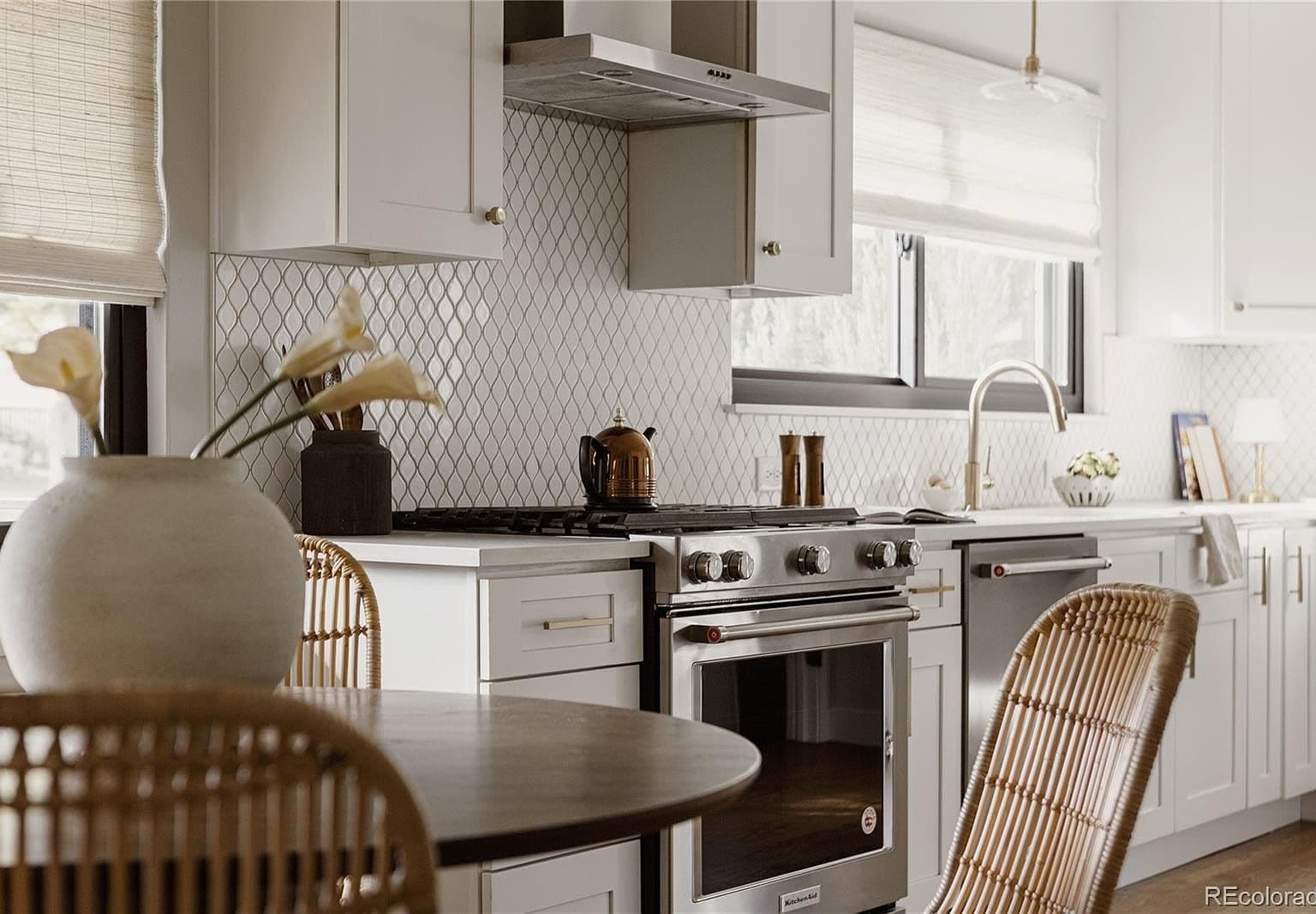 Quartz counters and patterned backsplash elevate the bright kitchen.