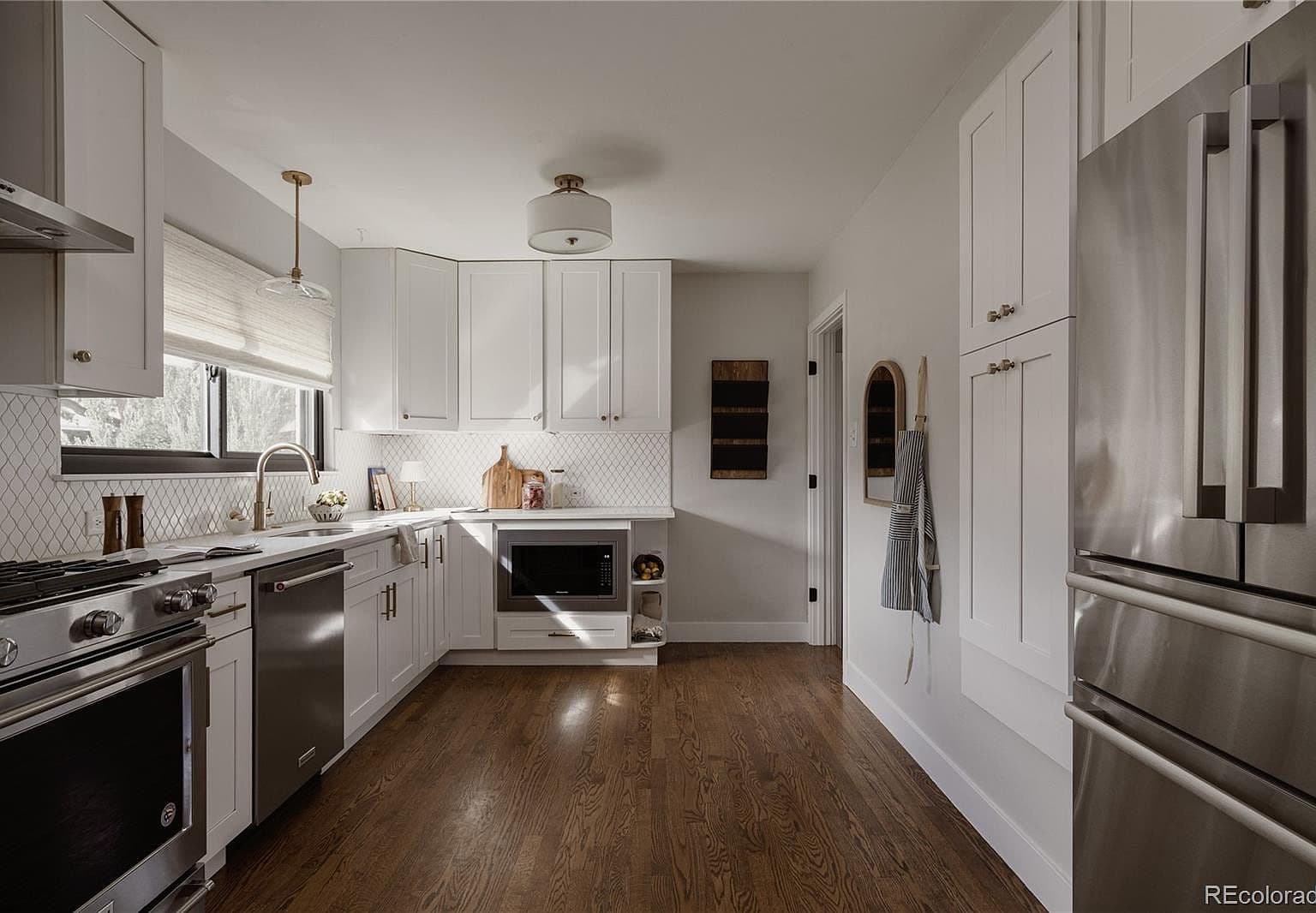 Spacious kitchen showcases quartz counters and stainless steel appliances.