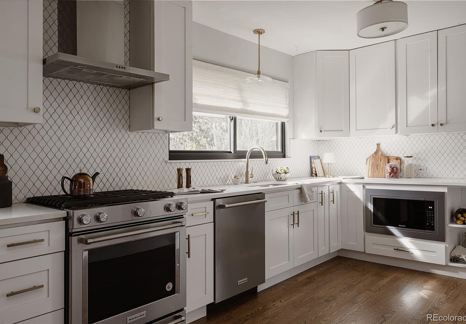 Quartz countertops wrap around a light-filled kitchen workspace.