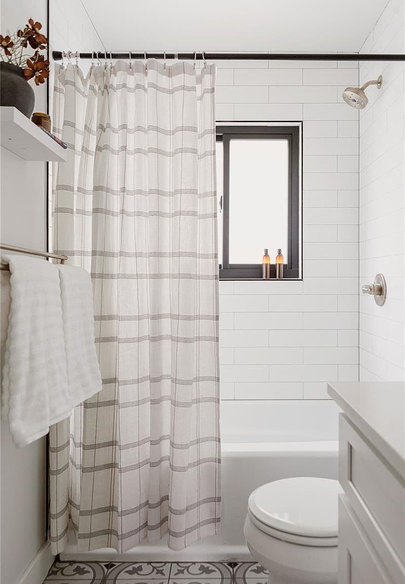 Window-lit tub and patterned floors add character to the bathroom.