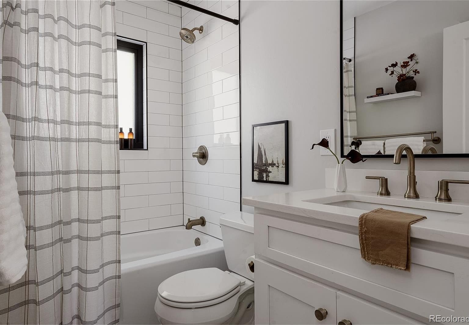 A crisp white vanity complements the tiled tub surround.
