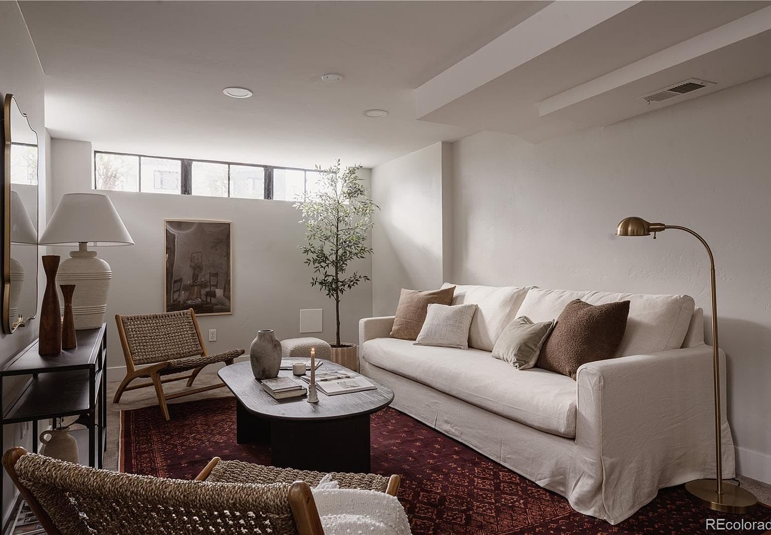 High windows bring natural light into the basement sitting area.