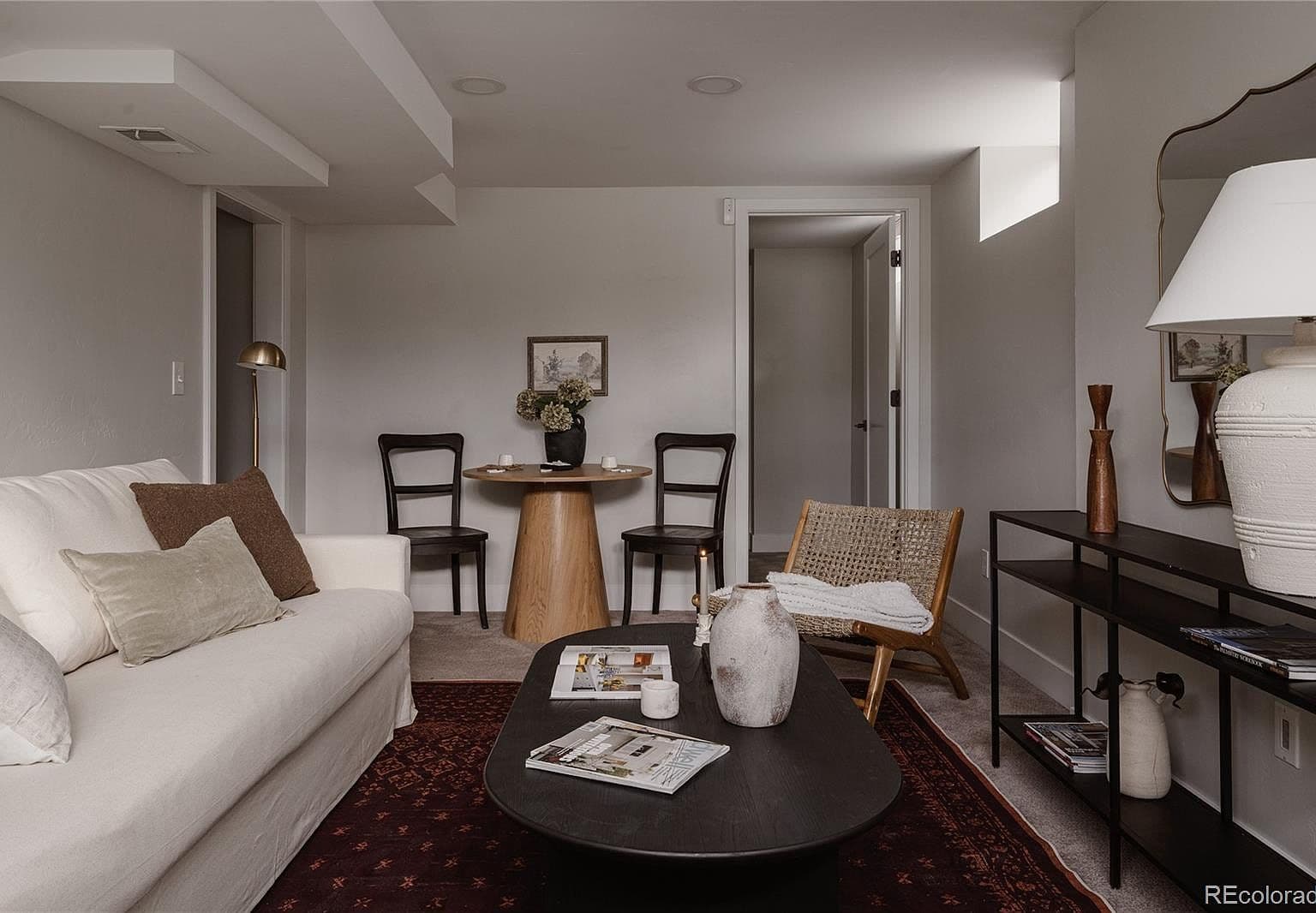 A cozy basement gathering space includes room for a café table.