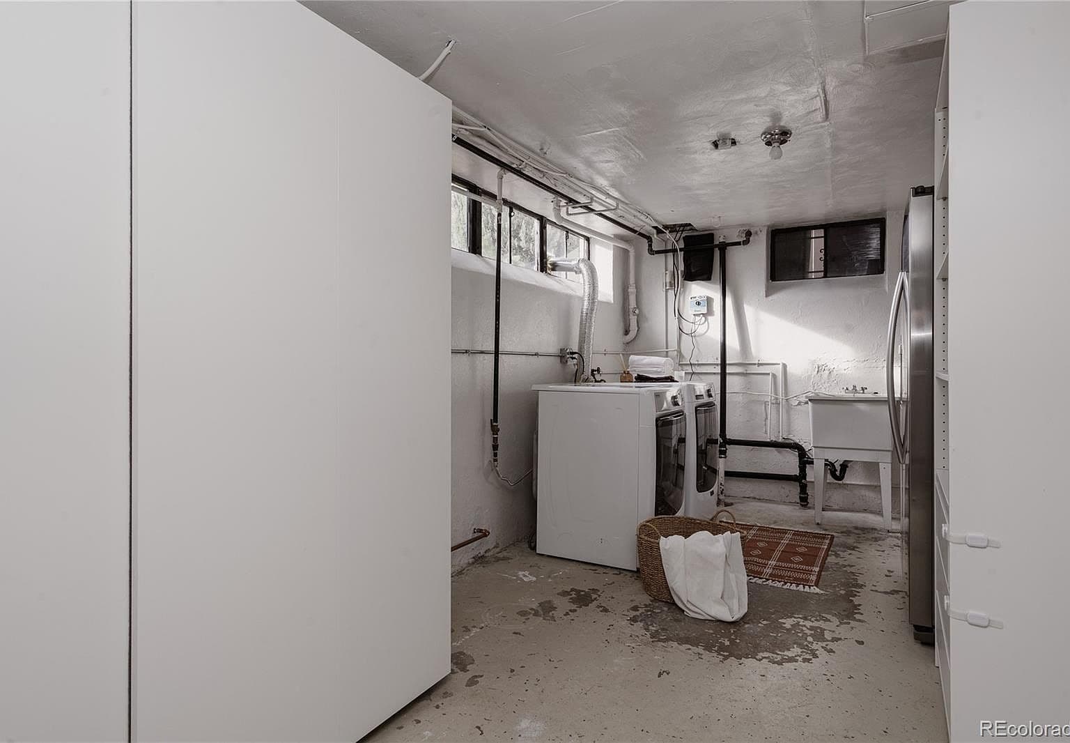 Dedicated laundry area with washer, dryer, and utility sink.