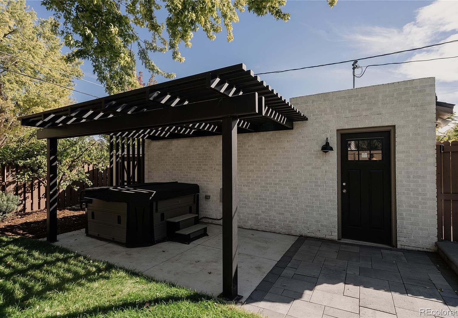 Pergola-covered hot tub creates a relaxing backyard retreat.