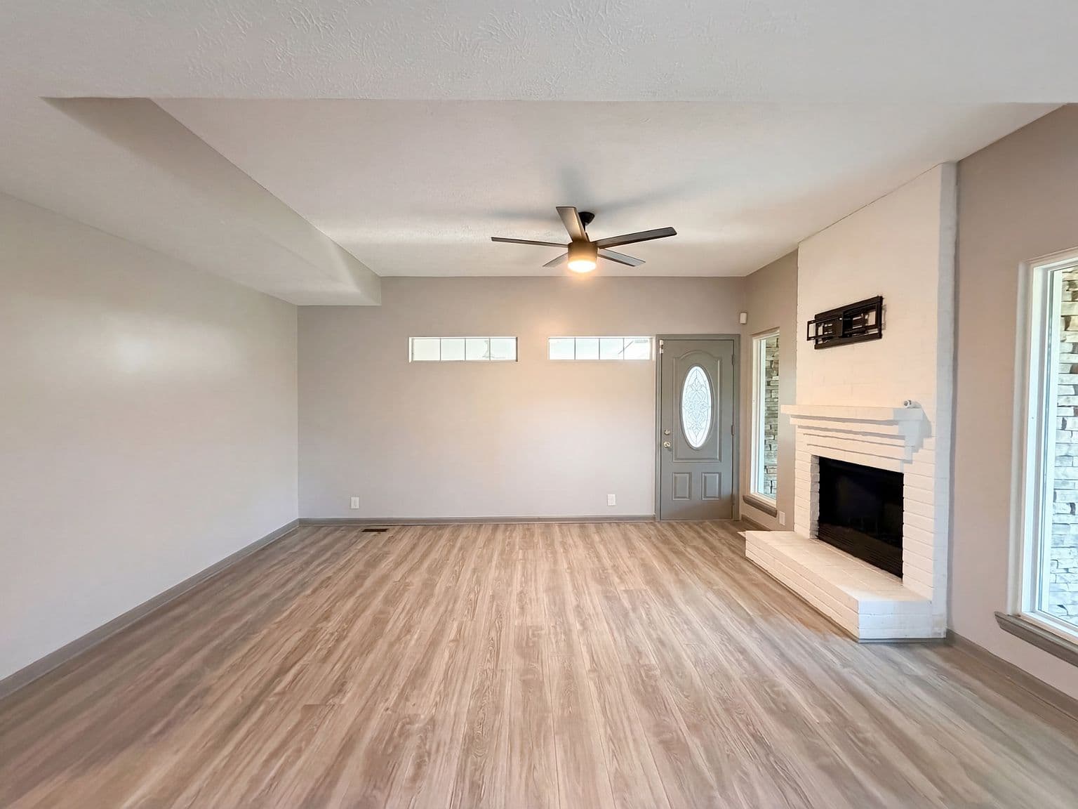 Bright living room with fireplace and updated flooring.