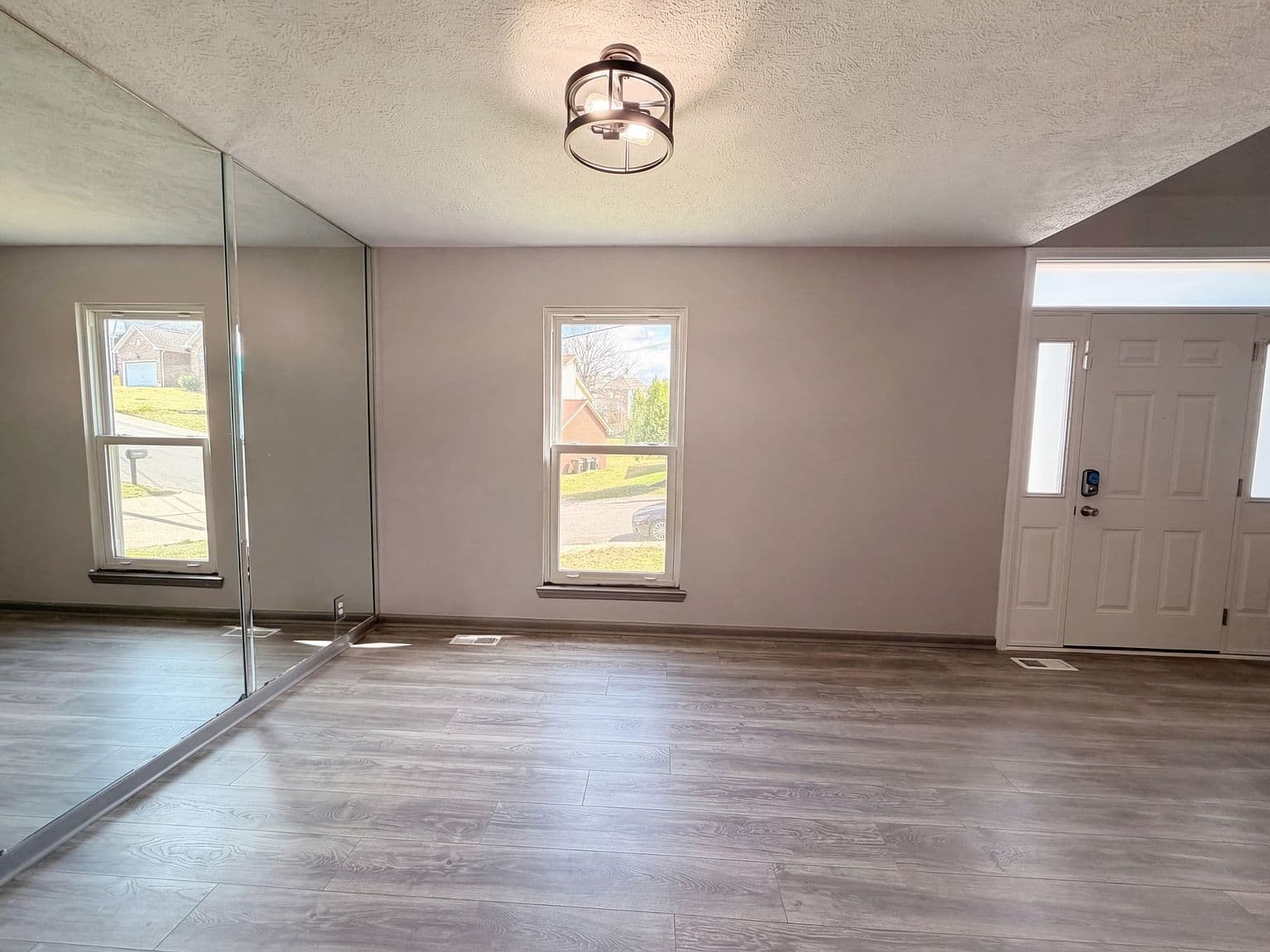 Welcoming entry with stylish lighting and laminate floors.