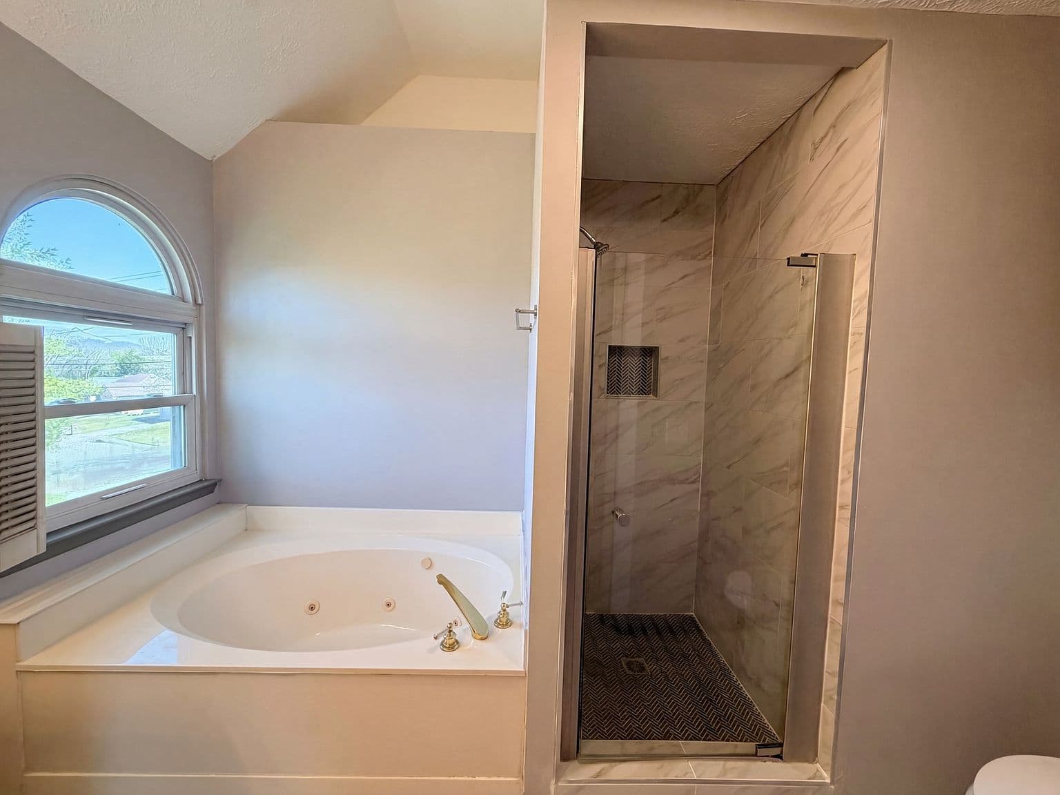 Spa-like primary bath with soaking tub and tiled shower.