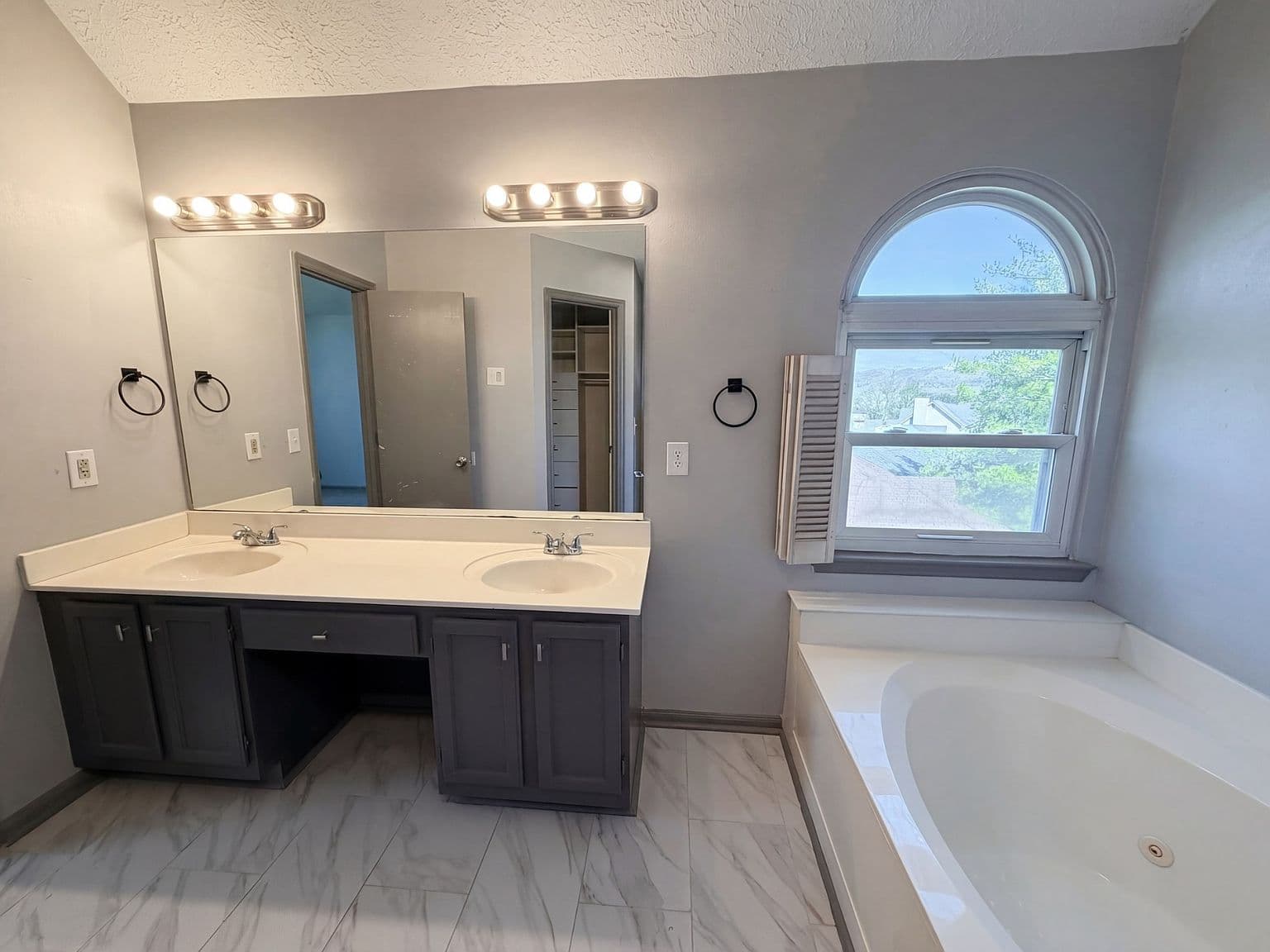 Primary bath with double vanity and relaxing soaking tub.