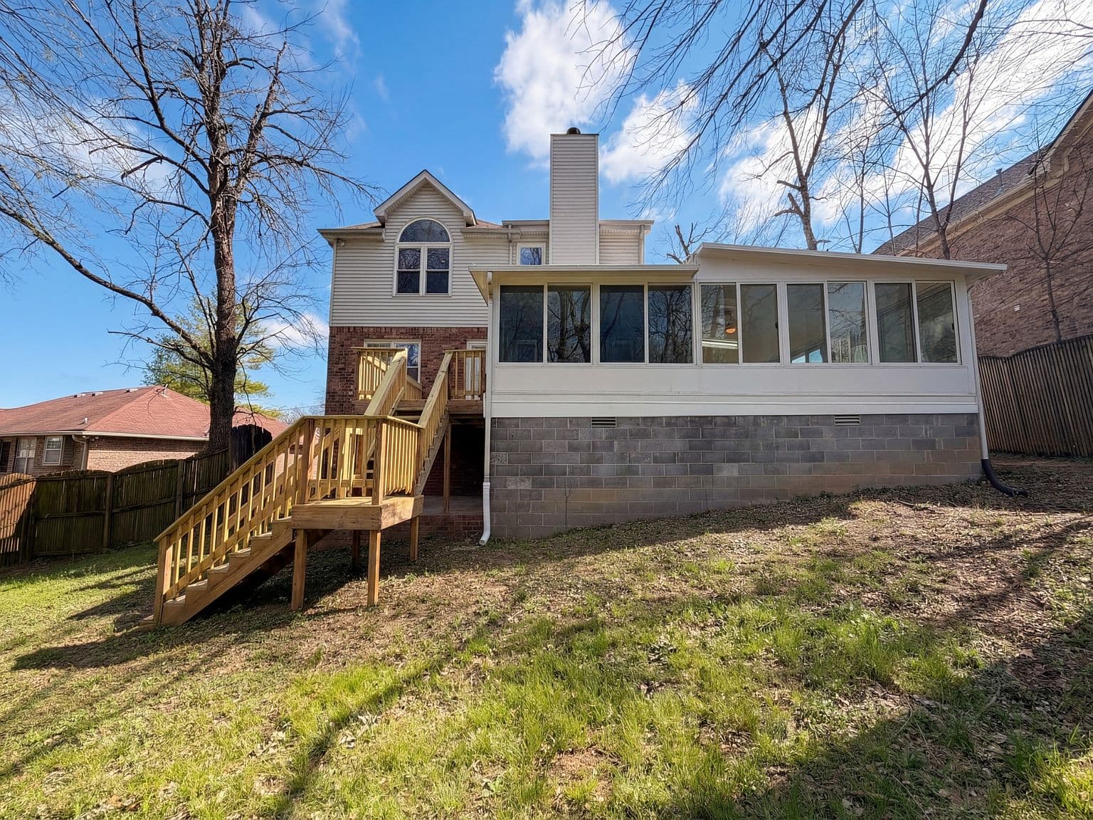 Rear elevation with deck access and sunny fenced yard.