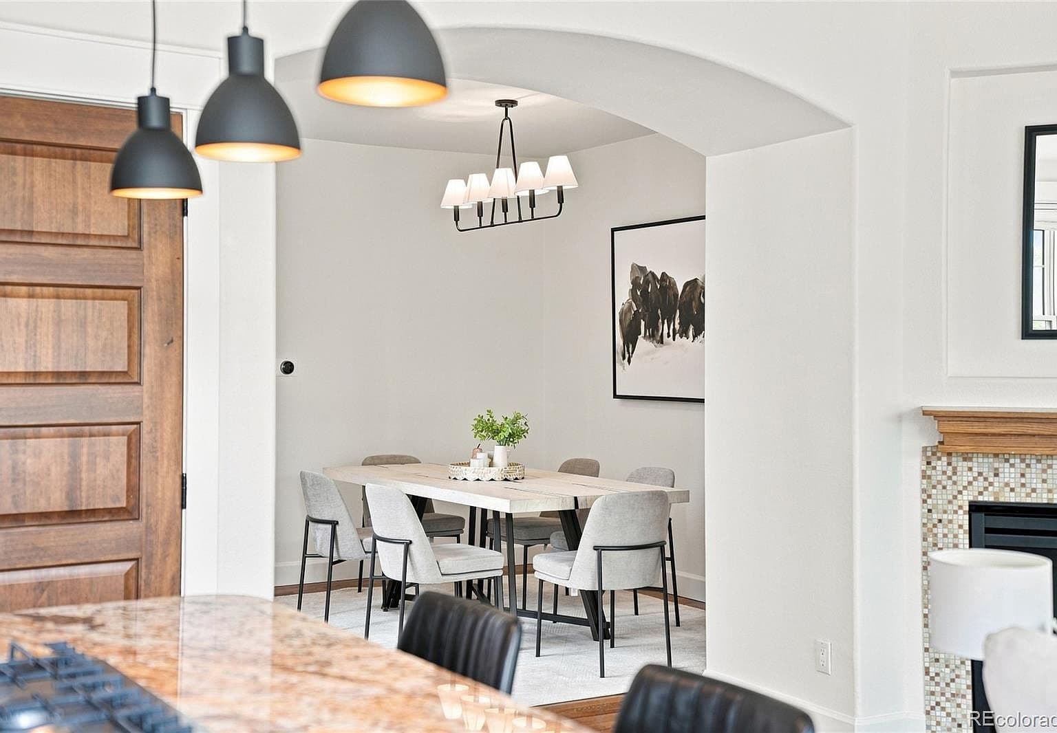 Bright dining nook with modern lighting and archway.