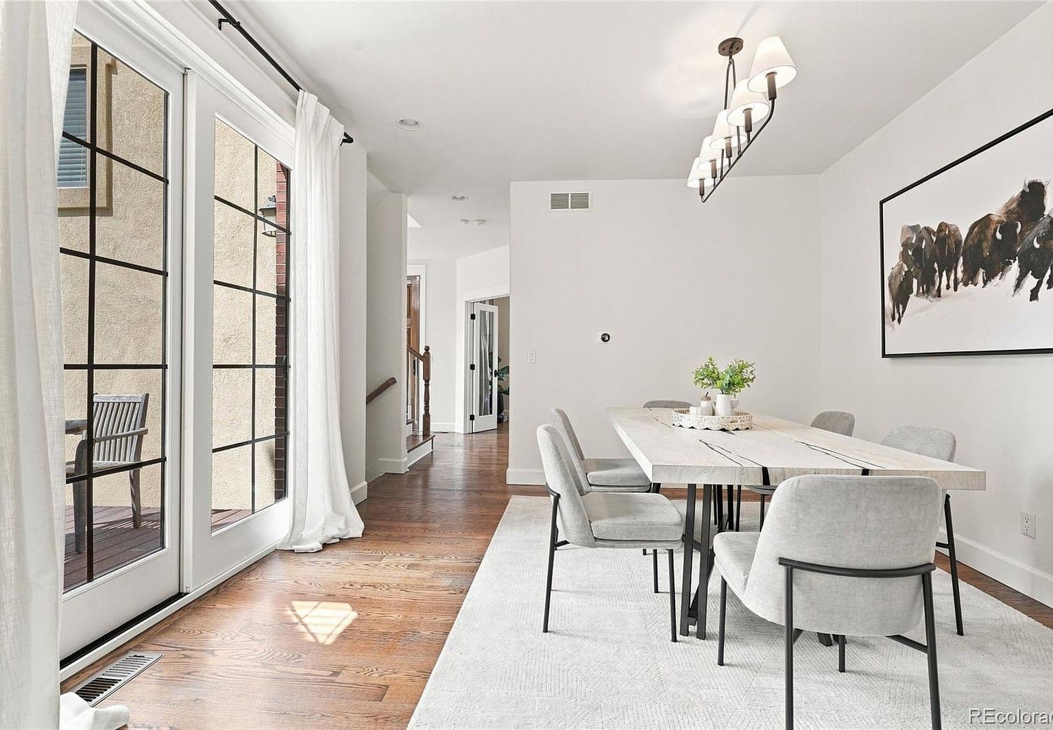 Dining area opens to patio through tall glass doors.
