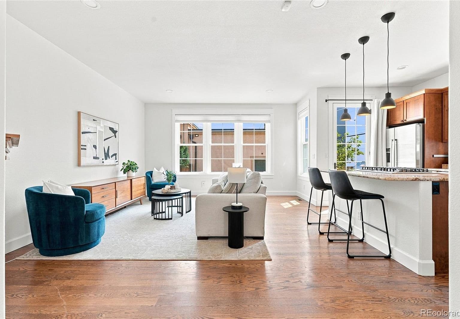 Sunlit open-concept living with breakfast bar seating.