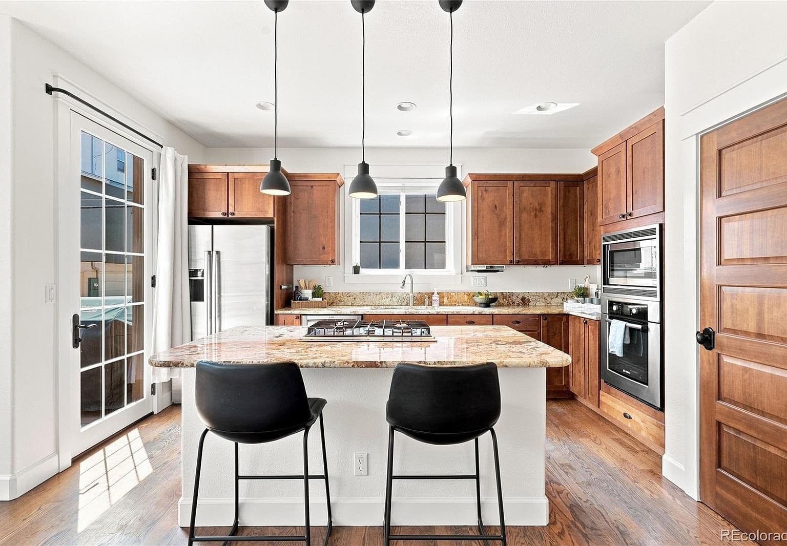Chef’s kitchen with granite island and gas cooktop.