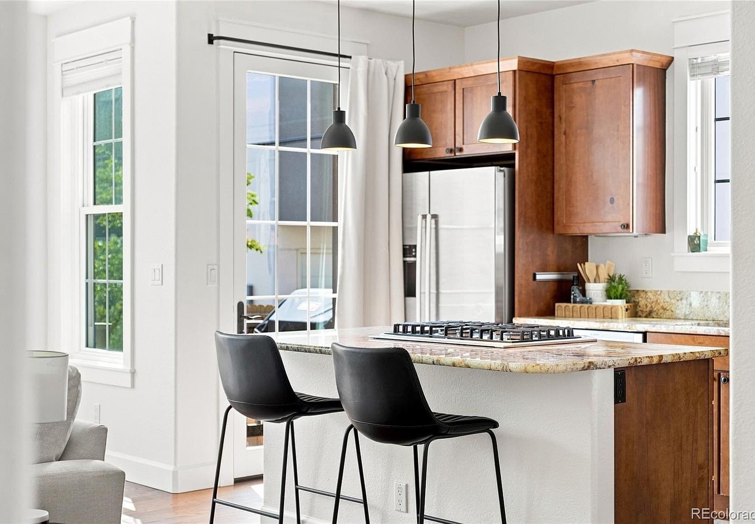 Breakfast-bar seating beside bright windows and patio door.